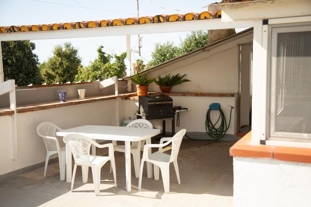 Terrazza soleggiata con tavolo e barbecue a Casa Petito
